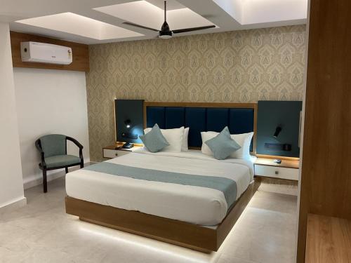 a bedroom with a large bed and a chair at Aurora Hotels and Resorts in Pulickamaly