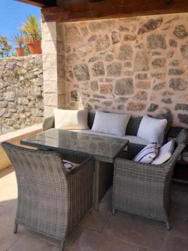 a patio with a table and chairs and a couch at Villa Anica Dubrovnik - luxurious with a sea view in Dubrovnik