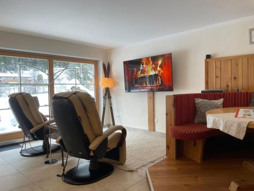 a living room with two chairs and a fireplace at Zillertal Residenz in Ginzling