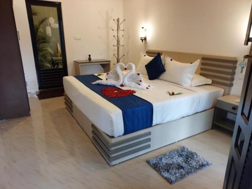 a bedroom with a bed with two swans on it at Marari Beach Way Inn in Alleppey