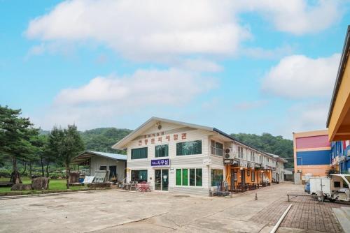 a building in the middle of a parking lot at Sungbochon Youth Hostel - Hostel in Mungyeong