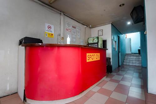 a red counter in a room with a red wall at Hotel O Gold Star Hotel in Sibu