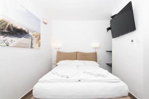 a bed in a room with a tv on a wall at Thomas's cozy room with Breakfast in Piran