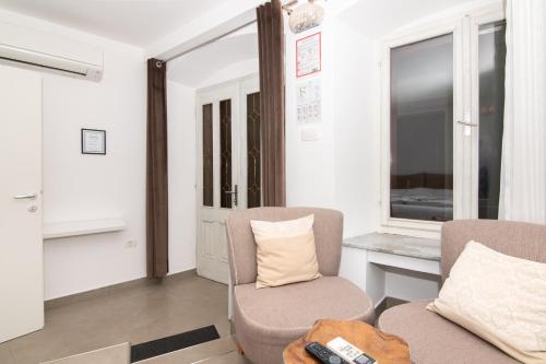 a living room with two chairs and a desk at Thomas's cozy room with Breakfast in Piran