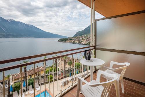a balcony with a table and chairs and a view of the water at Hotel Splendid Palace in Limone sul Garda