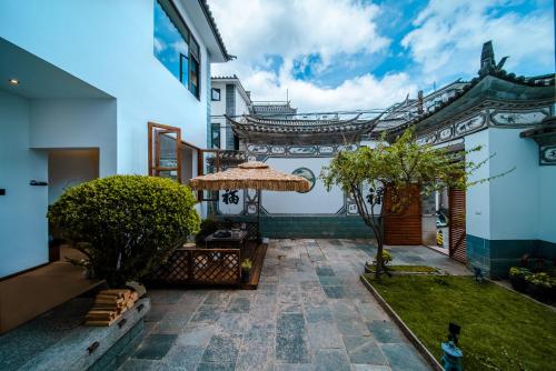 a courtyard of a house with an umbrella at The Whisperer Guanshan Private Residence Hotel in Dali