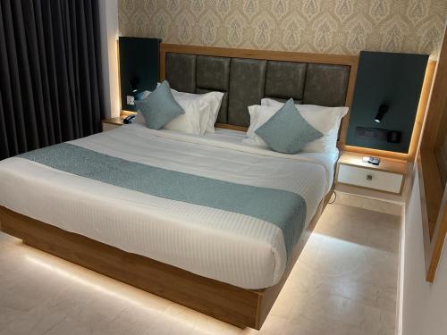 a bedroom with a large bed with blue pillows at Aurora Hotels and Resorts in Pulickamaly