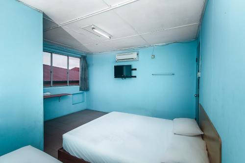 a room with two beds and a blue wall at Hotel O Gold Star Hotel in Sibu