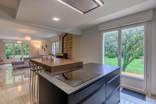 une cuisine avec un îlot et un salon dans l'établissement Ty-Gwenn - Grande Maison de campagne familiale, à Surzur