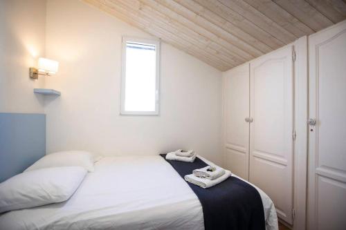 ein Schlafzimmer mit einem Bett, auf dem zwei Handtücher liegen in der Unterkunft La Misaine, les Minimes, LR117 in La Rochelle