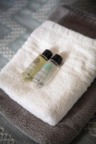 deux bouteilles d'hydratants assises sur une serviette blanche dans l'établissement La Misaine - Wifi Parking, à La Rochelle