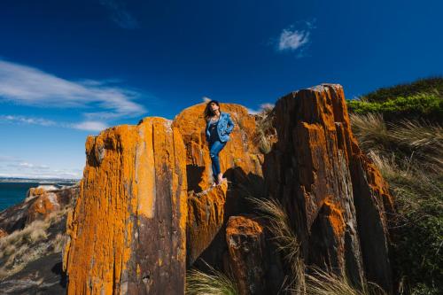 a woman standing on a rock on the beach at Devonport Breeze Escape in Devonport