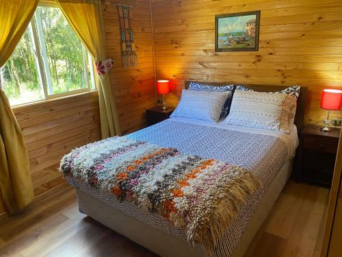カストロにあるCabañas Los Fabianesの丸太小屋のベッドのある寝室