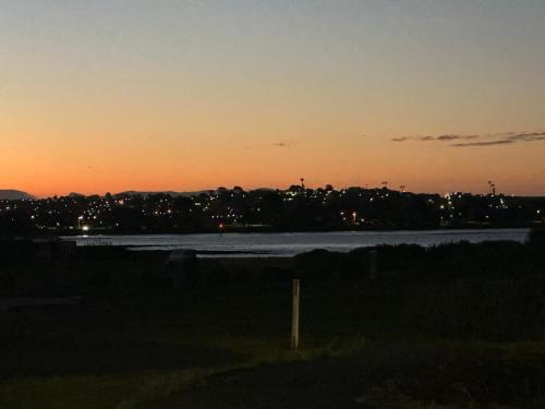 a sunset over a body of water at dusk at Devonport Breeze Escape in Devonport