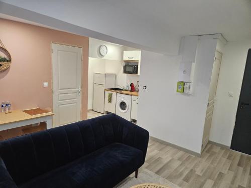 a living room with a couch and a kitchen at Appartement T2 cosy à 5min à pieds de la gare in Valenciennes