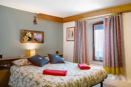 a bedroom with a bed with two red pillows on it at Maison Cerise Pila in Gressan