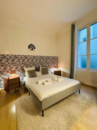 une chambre avec un grand lit dans une pièce dans l'établissement Élégant Appartement à Paris 16e, à Paris