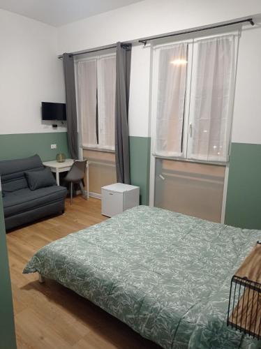 a bedroom with a bed and a couch and a table at Unmei Home in Rome