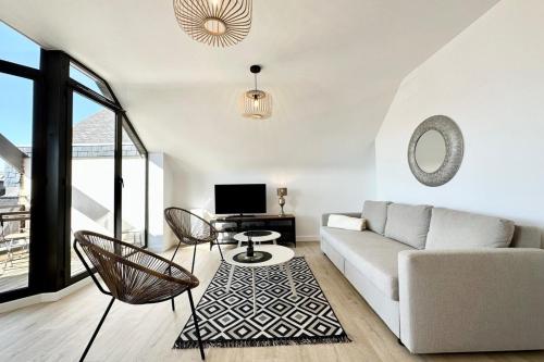 un salon avec un canapé et une télévision dans l'établissement T2 Neuf Top Cocooning Terrasse - Face à la mer, à Ploemeur