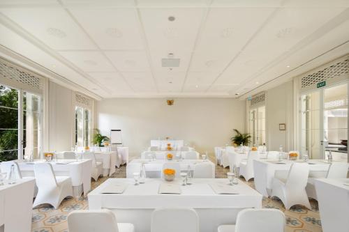 a banquet hall with white tables and white chairs at Rumah Luwih Bali in Keramas