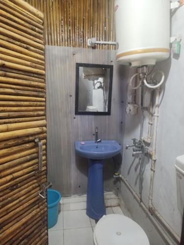 a bathroom with a blue sink and a toilet at Forest Bliss Resort in Dehradun