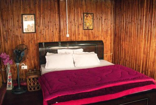 a bedroom with a bed with a red blanket at Forest Bliss Resort in Dehradun