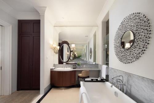 a bathroom with a tub and a sink and a mirror at Rumah Luwih Bali in Keramas