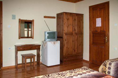 a room with a refrigerator and a tv on top at To Petrino Guesthouse in Agios Germanos