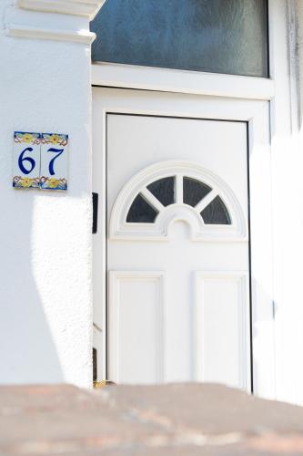 a white garage door with a sign on it at Open Mind Property - Cosy Home - 7 Beds & Parking in Portsmouth