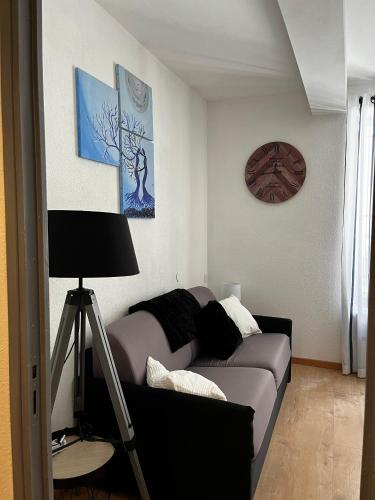 un salon avec un canapé et une horloge au mur dans l'établissement Cosy BEFFROI, à Narbonne
