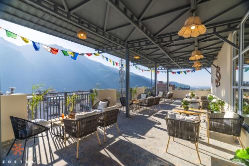 a patio with chairs and tables on a balcony at Zostel Rishikesh, Tapovan in Rishīkesh