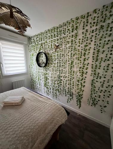une chambre avec un mur recouvert de plantes vertes dans l'établissement Paisible appartement proche futuroscope, à Buxerolles