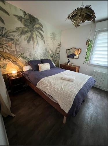 - une chambre avec un lit orné d'une fresque murale de palmiers dans l'établissement Paisible appartement proche futuroscope, à Buxerolles