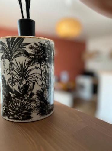 une tasse noire et blanche assise au-dessus d'une table dans l'établissement Paisible appartement proche futuroscope, à Buxerolles