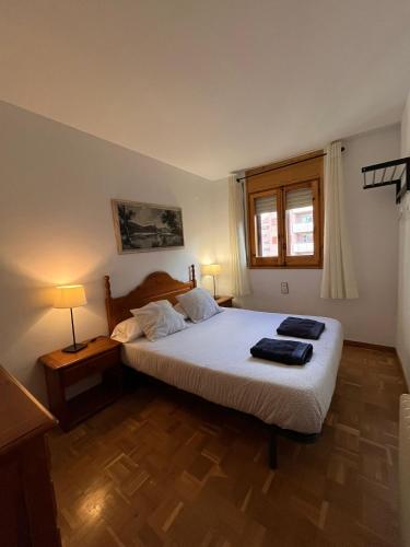 a bedroom with a bed with two towels on it at Los Sauces II in Jaca