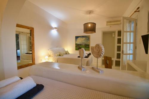 a bedroom with a bed and a large mirror at Blue Bay Heliolithos in Parikia