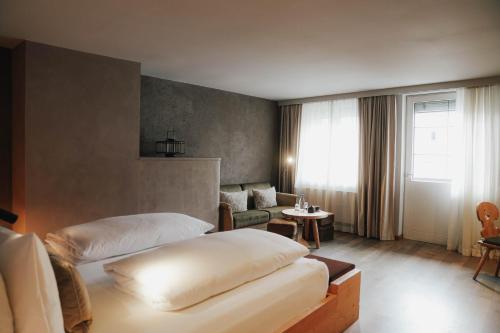 a hotel room with two beds and a table at Boutiquehotel Weisses Rössl in Innsbruck