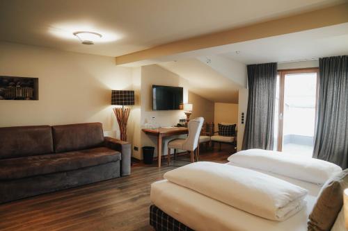 a hotel room with two beds and a couch at Boutiquehotel Weisses Rössl in Innsbruck