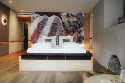 a bedroom with a bed with a painting on the wall at Boutiquehotel Weisses Rössl in Innsbruck