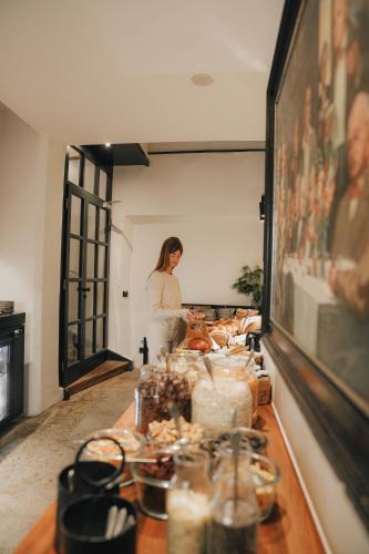 a woman is standing behind a table with food at Boutiquehotel Weisses Rössl in Innsbruck