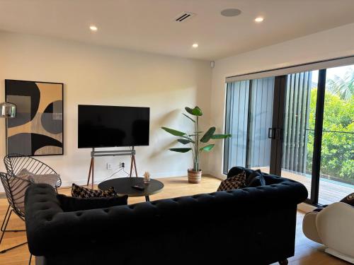 a living room with black furniture and a flat screen tv at Epsom Tidy House Unit 6 in Auckland