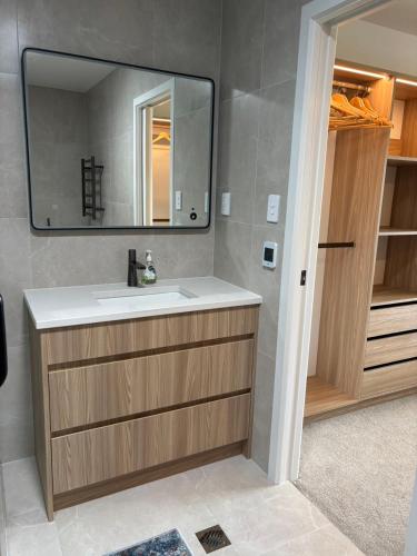 a bathroom with a sink and a mirror at Epsom Tidy House Unit 6 in Auckland