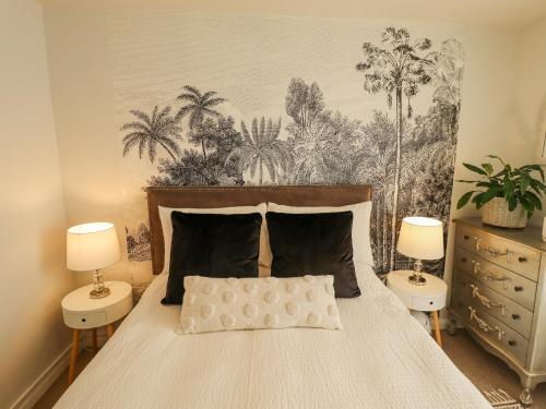 a bedroom with a bed with two night stands and two lamps at Lavender Cottage in Louth