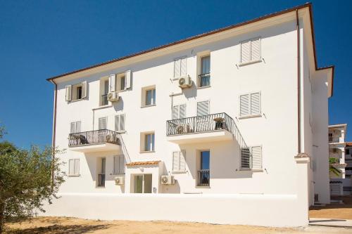 a white building with balconies on the side at Le Residenze del Baia Marina in Orosei