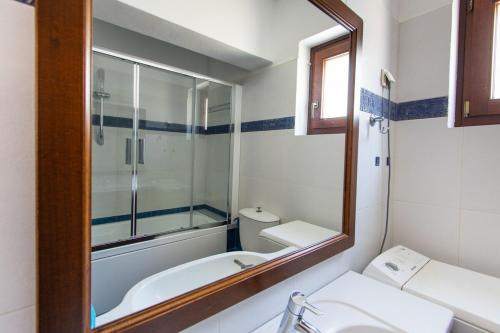 a bathroom with a tub and a sink and a mirror at Fabulous Holiday Villa in Naxos Island in Agios Prokopios