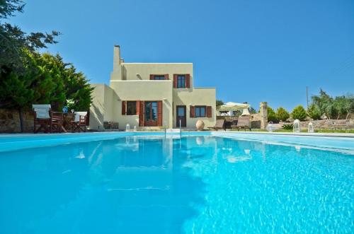 a large swimming pool in front of a villa at Fabulous Holiday Villa in Naxos Island in Agios Prokopios