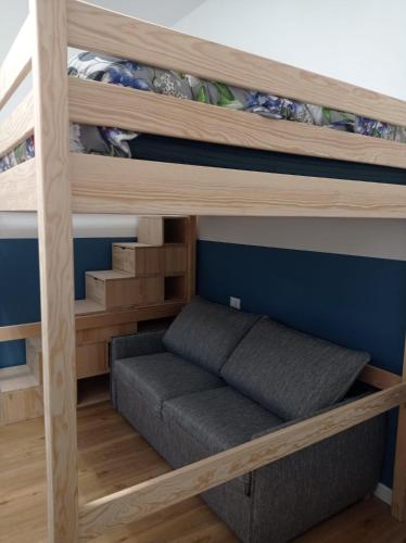 a bunk bed with a couch in a room at Unmei Home in Rome