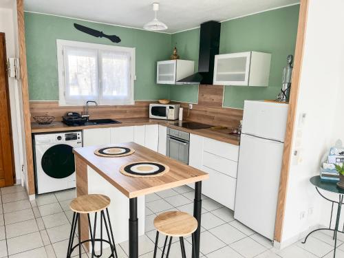 - une cuisine avec une table et quelques tabourets dans l'établissement Villa Marguerite, à Mèze