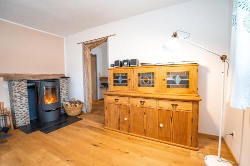 a living room with a wooden cabinet and a fireplace at Apartement Gute Laune in Mieming