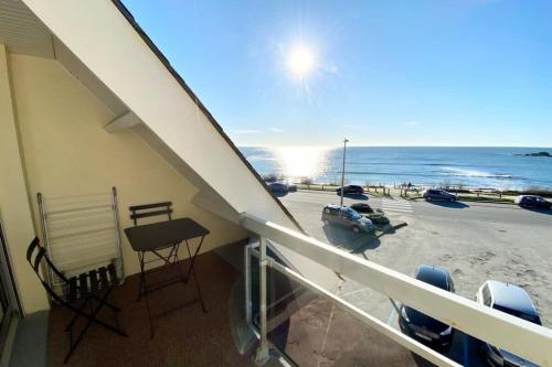 Elle comprend un balcon offrant une vue sur un parking et l'océan. dans l'établissement Joli appartement Top Cosy Vue mer imprenable 180, à Ploemeur
